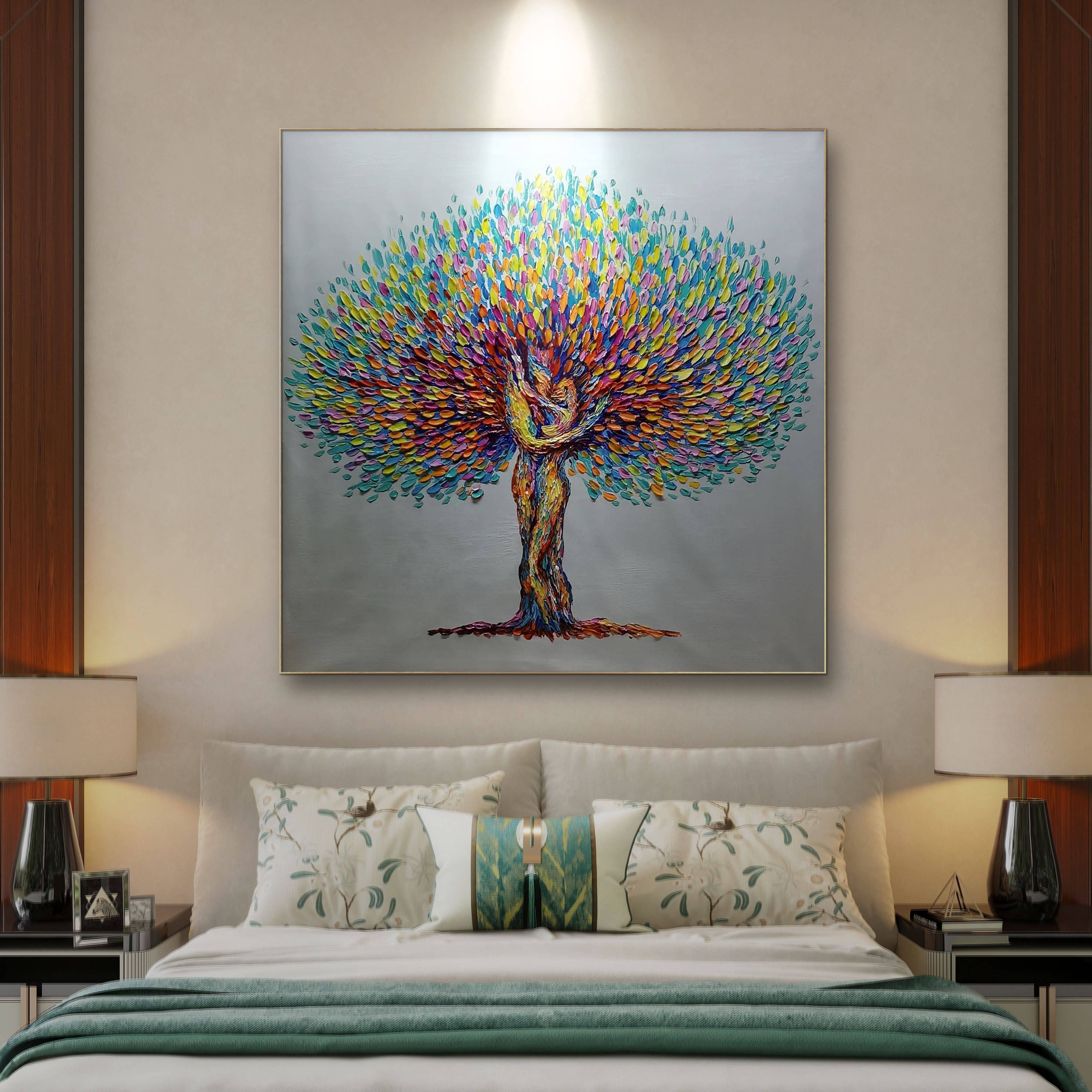 A hand-painted, colorful artwork of a tree with a couple embracing, displayed on a wall in a room with two lamps and a bed.