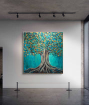 Artistic depiction of a tree with blue and gold leaves on a white wall.