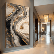 Abstract art piece with gold and black patterns on a wall in a modern hallway.