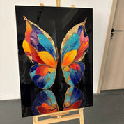 Colorful butterfly artwork on a black background with an easel.