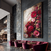 Modern interior with red chairs and a large floral painting on a stone wall.