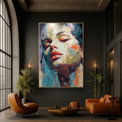 Modern living room with a large abstract painting of a woman's face on a dark wall.